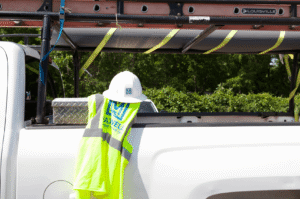 maxwell roofing hard hat and vest on company truck