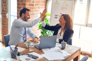 two office workers high fiving