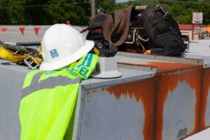 maxwell roofing vest and hardhat on job site