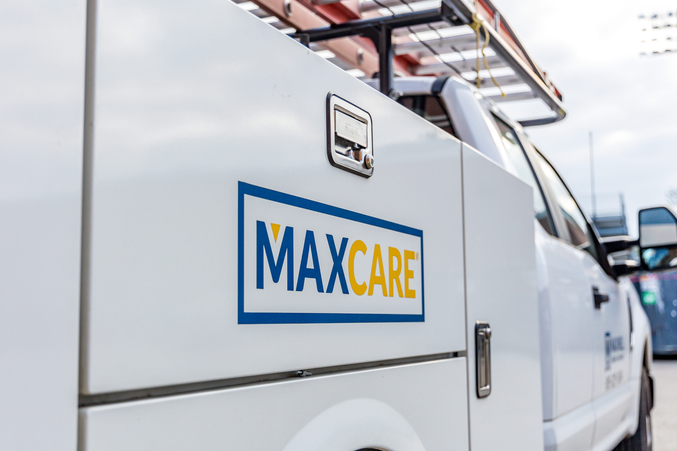 Maxwell Roofing Maxcare logo on roofing service truck