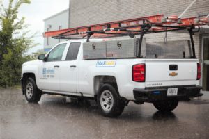 maxwell roofing truck at a commercial roofing job site in the rain