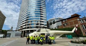 maxwell team standing with helicopter